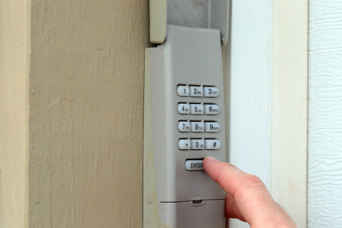 A person pressing buttons on their garage door keypad