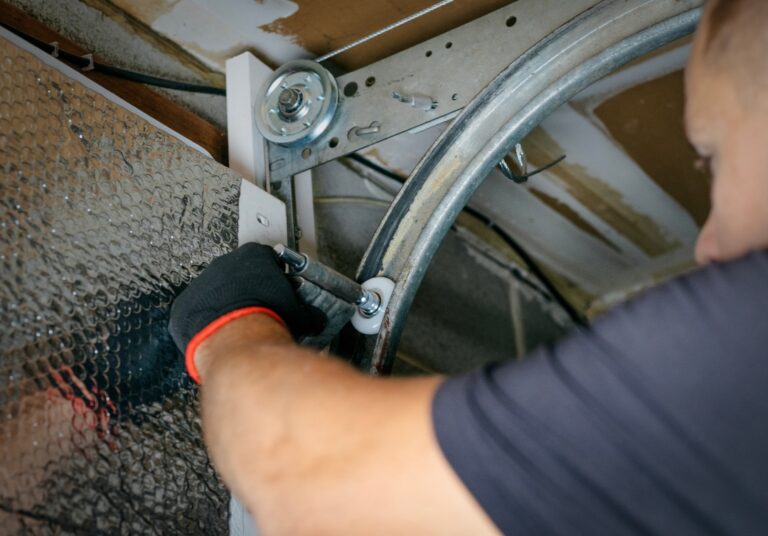A professional technician performs garage door maintenance for a customer