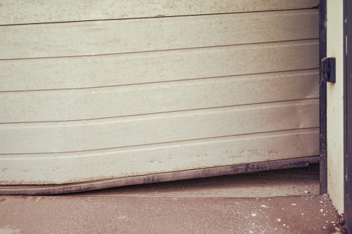 A garage door off track and hanging sideways