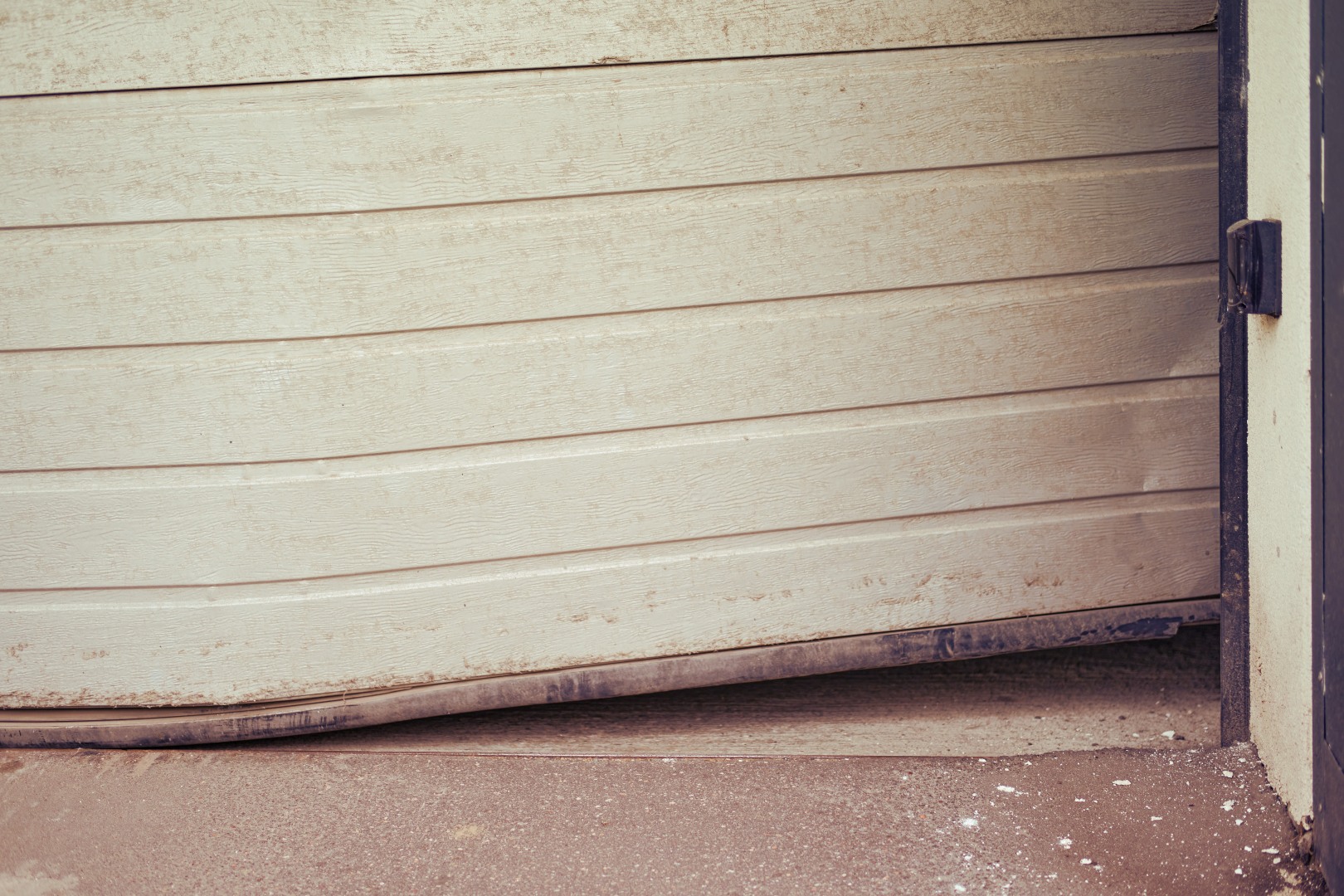 A garage door off track and hanging sideways