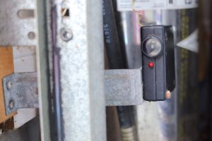 It's important to understand garage door safety features such as the photo-eye sensor in this picture.