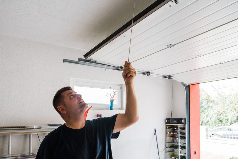 Homeowner practicing garage door safety by checking the manual operation of his door.