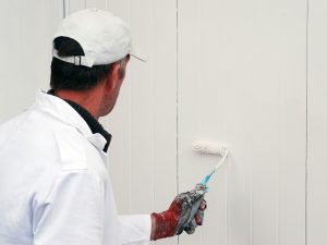 After learning how to paint a garage door, this homeowner has begun priming his door.