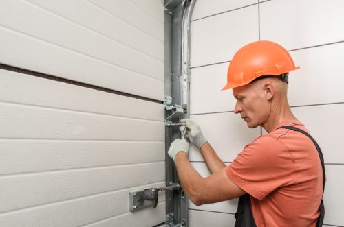 A garage door technician performing garage door installation